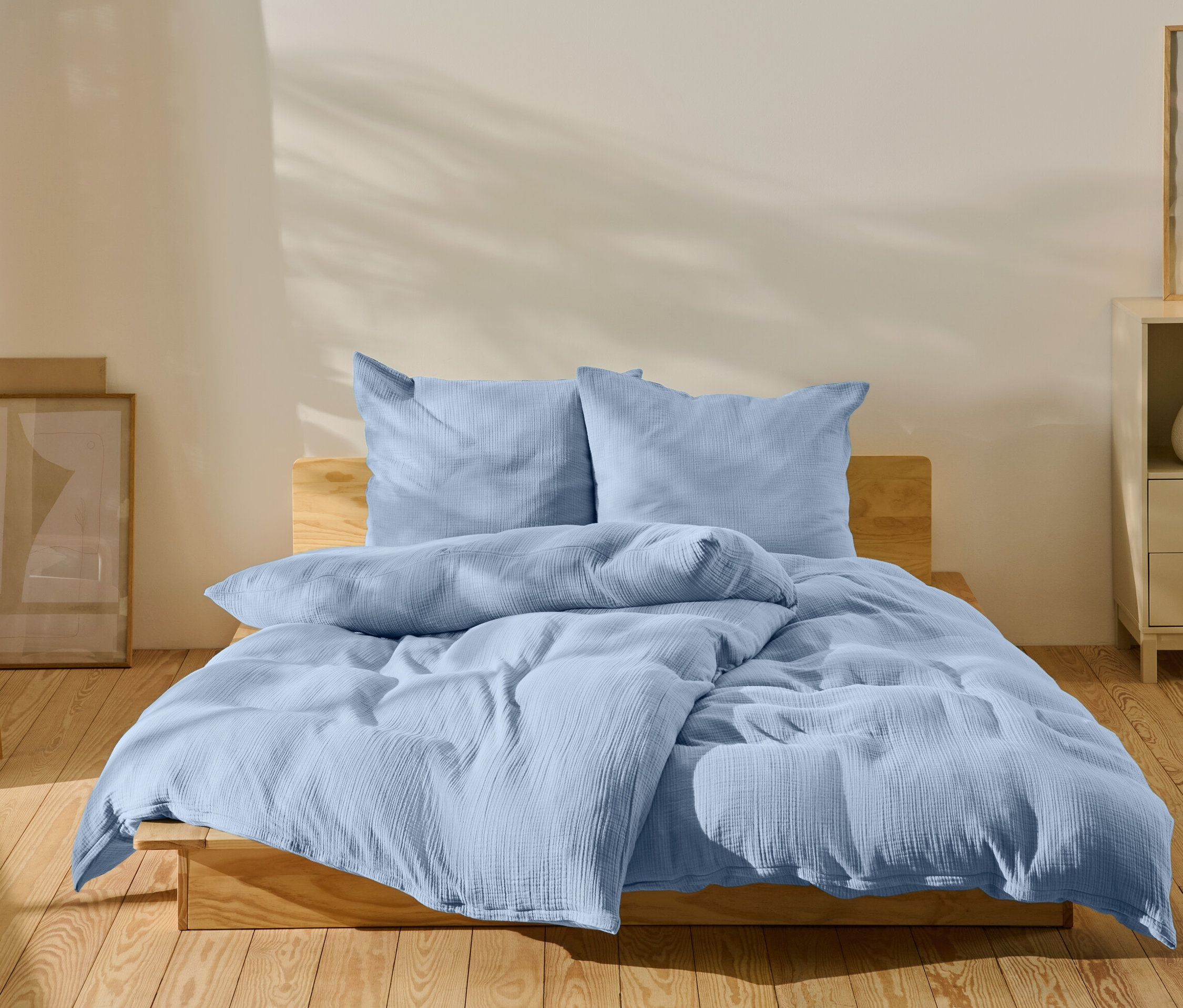 Világoskék ágynemű egy ágyon egy hálószobában.