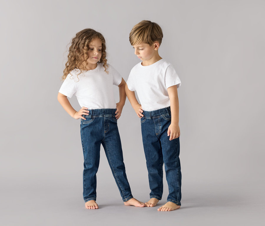 Két gyerek pózol fehér pólóban és sötétkék Belebújós nadrág gyerekeknek – Fit »Luca« nadrágban.