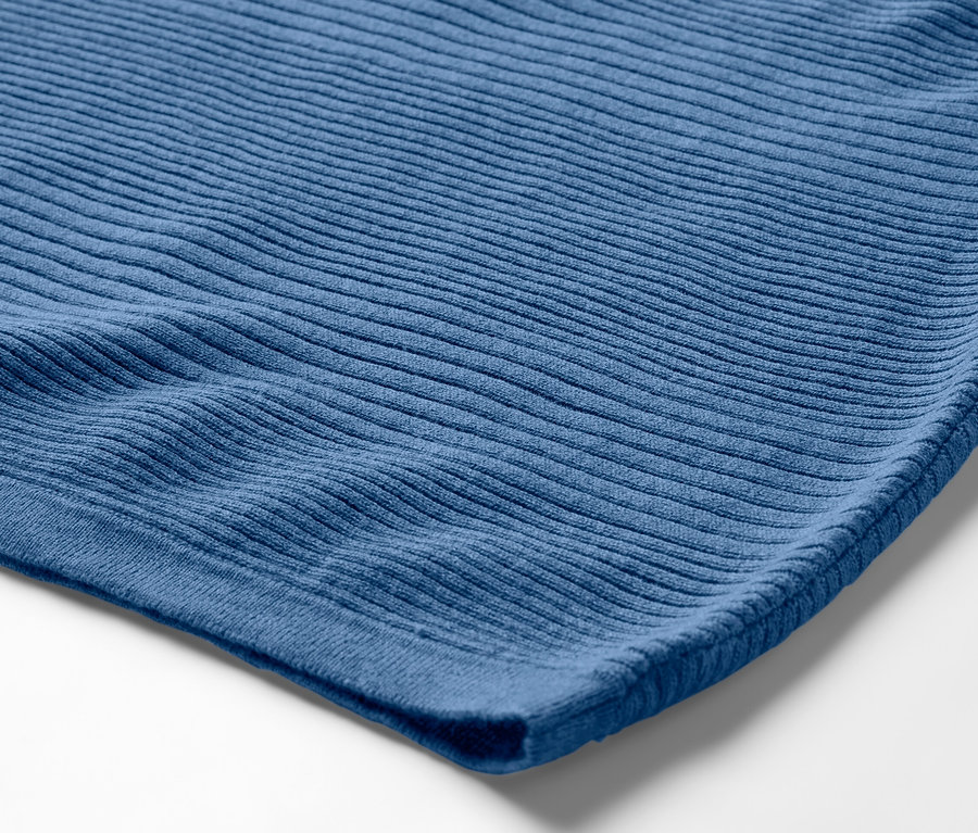 Kék, finom kötésű pulóver részlete.