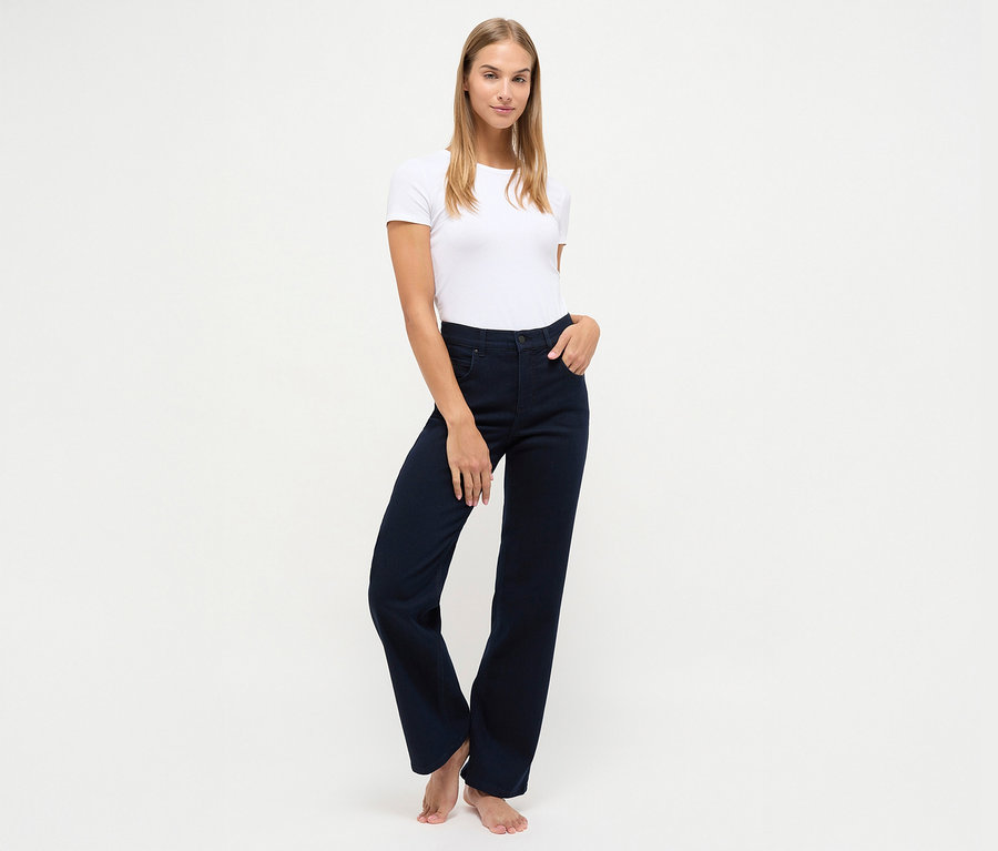 Egy nő pózol sötétkék Angels denim »Lara« straight fit farmernadrágban és fehér pólóban.