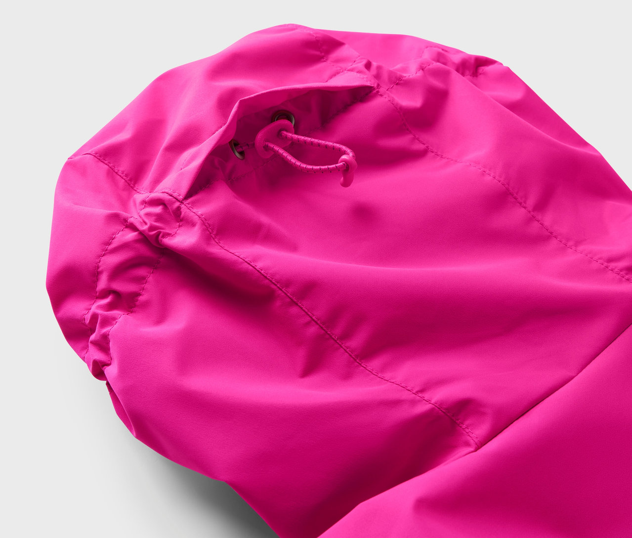 Egy rózsaszín kabát kapucnijának részlete húzózsinórral.