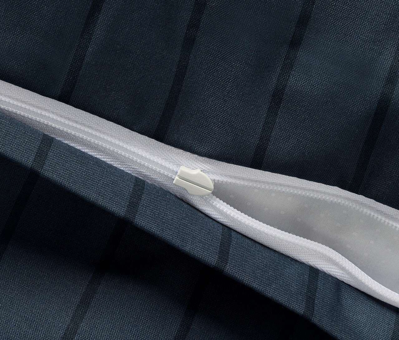 Közelkép egy normál méretű, renforcé ágynemű cipzárjáról.