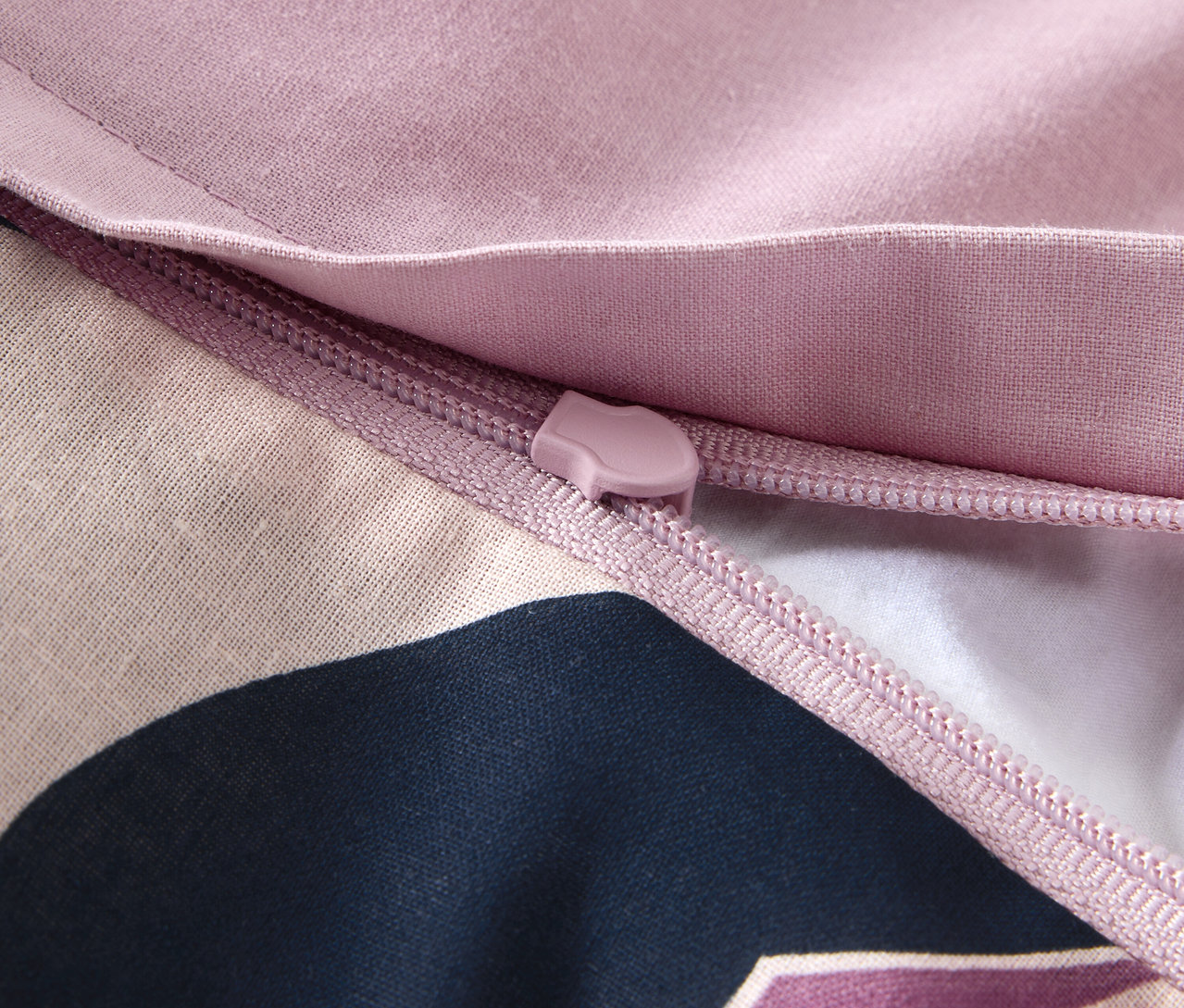 Közelkép egy normál méretű, renforcé ágynemű cipzárjáról.