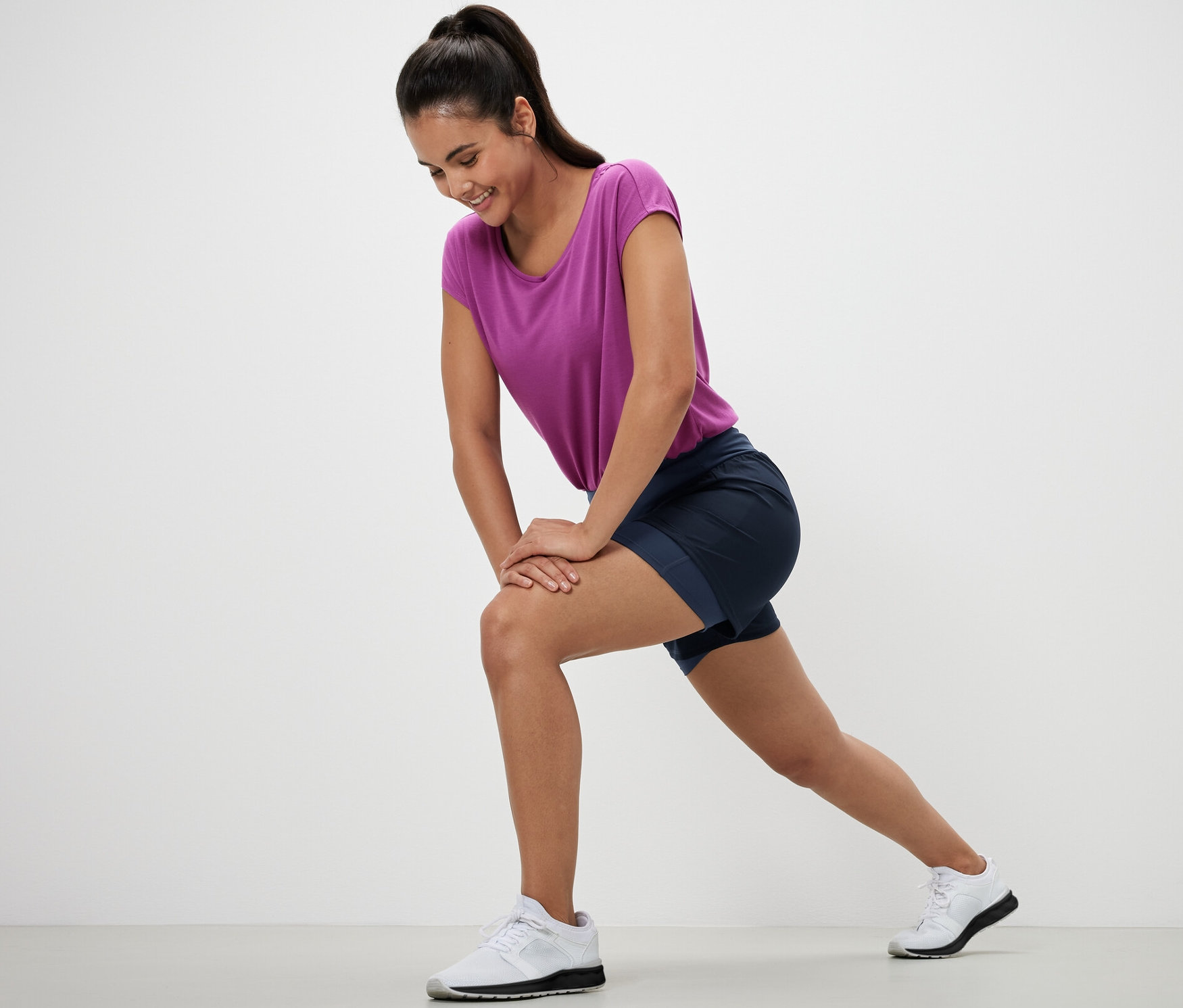 Nő nyújtózkodik 2 az 1-ben rövid futónadrágban.