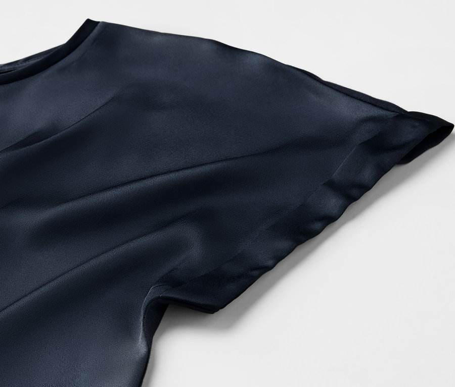 Egy tengerészkék, többféle anyagból készült ingblúz részlete.