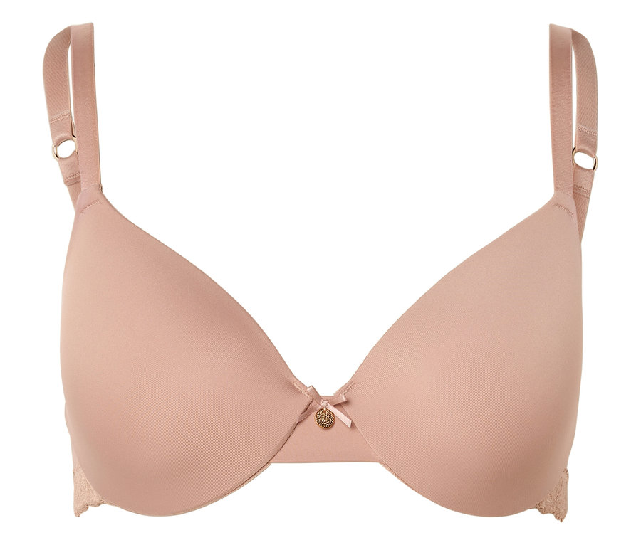 Egy testszínű melltartó állítható pántokkal, masnival és egy kis arany színű medállal a közepén.