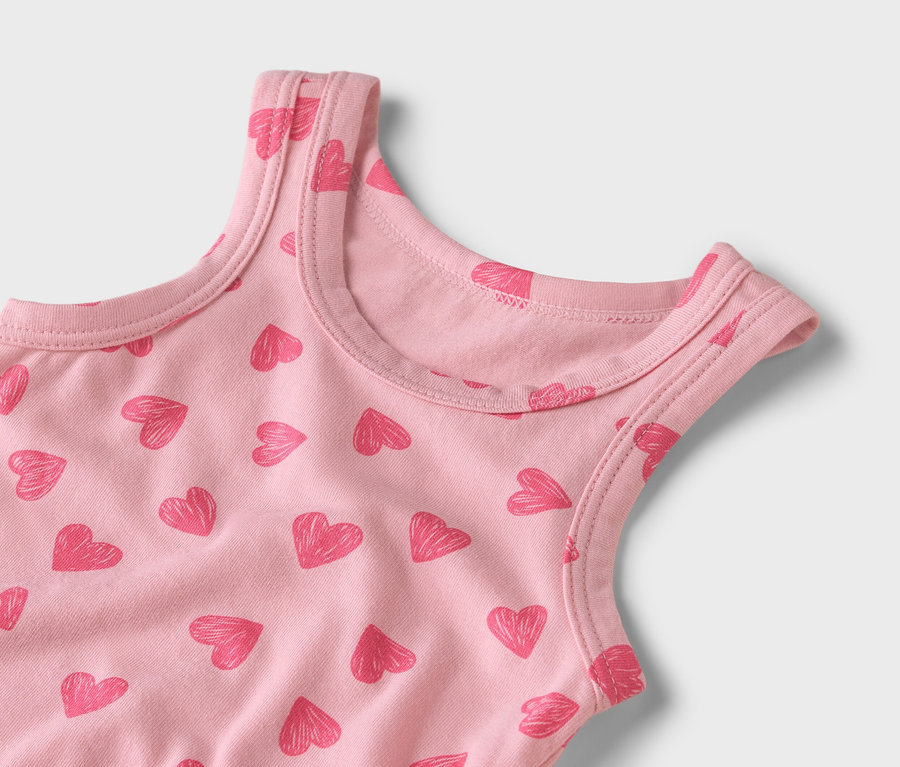 Egy rózsaszín, piros szívecskés mintájú trikó közeli képe.
