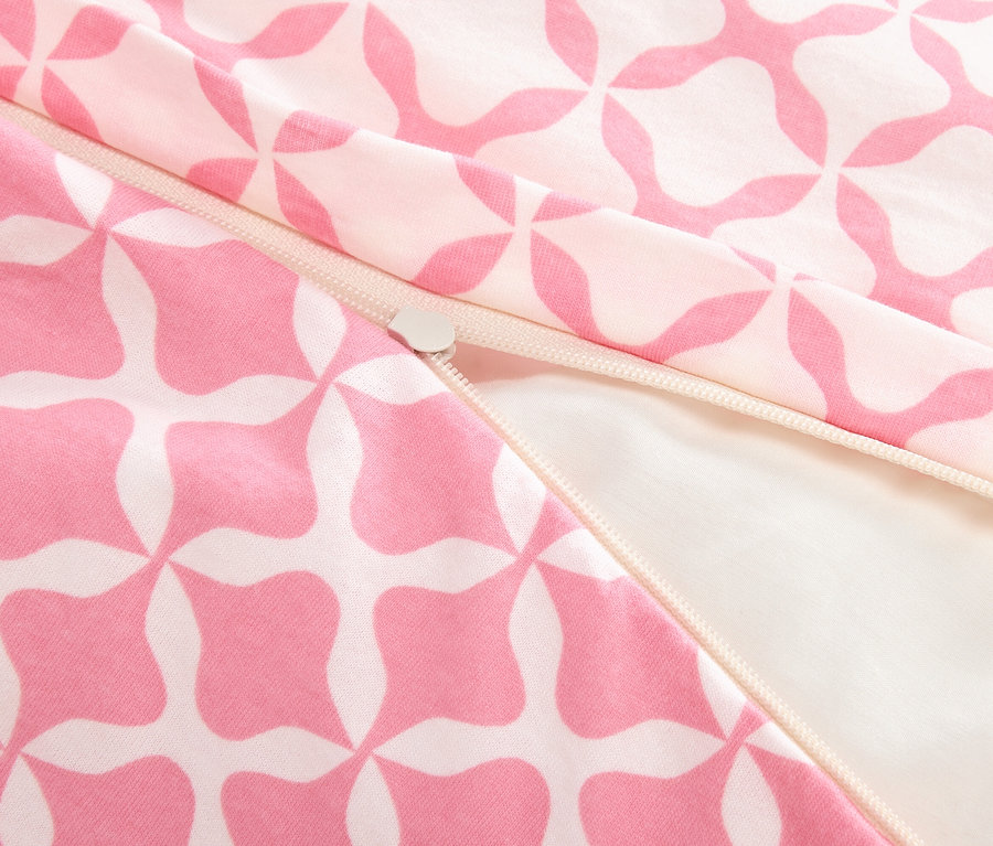 Egy részben nyitott cipzár közeli képe rózsaszín-fehér mintás szöveten.