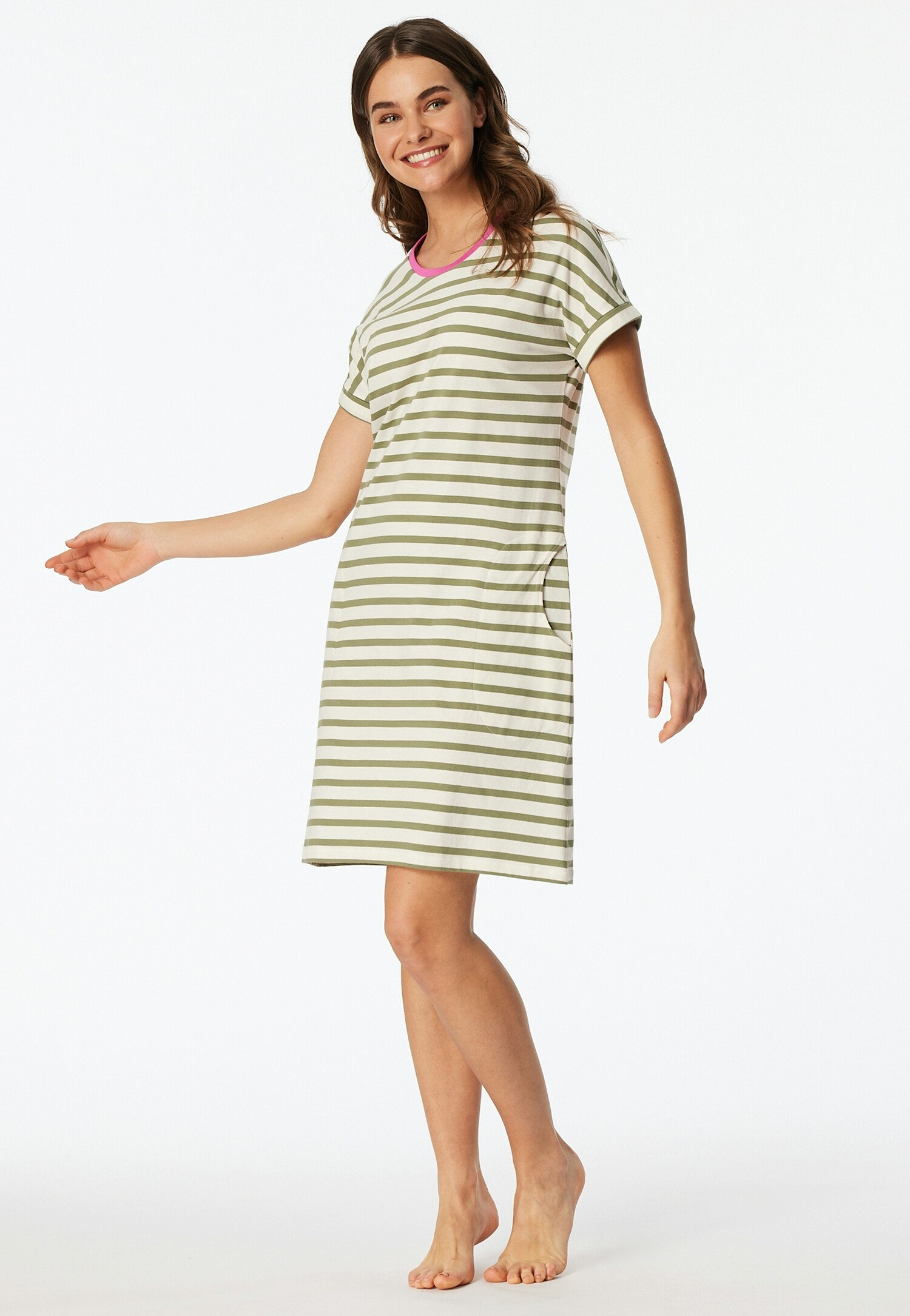 Nő visel egy csíkos pólóruhát rózsaszín részletekkel a nyakkivágásnál.