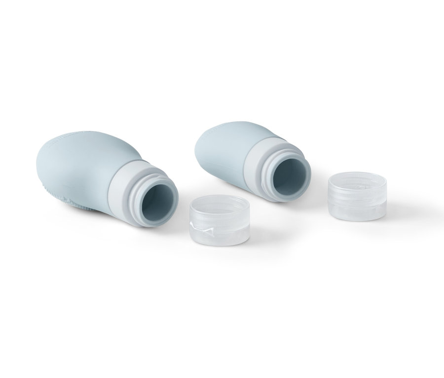 Két világoskék samponos flakon átlátszó kupakkal fehér háttéren.