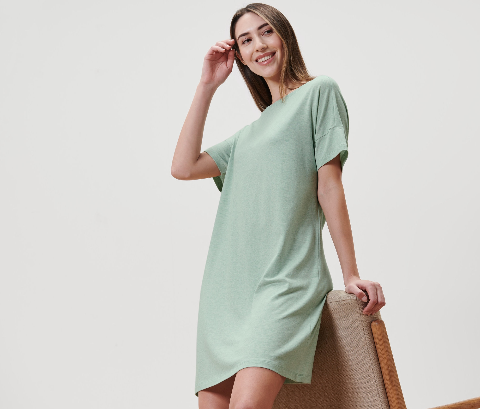 Nő pózol a menta színű női hálóingben.