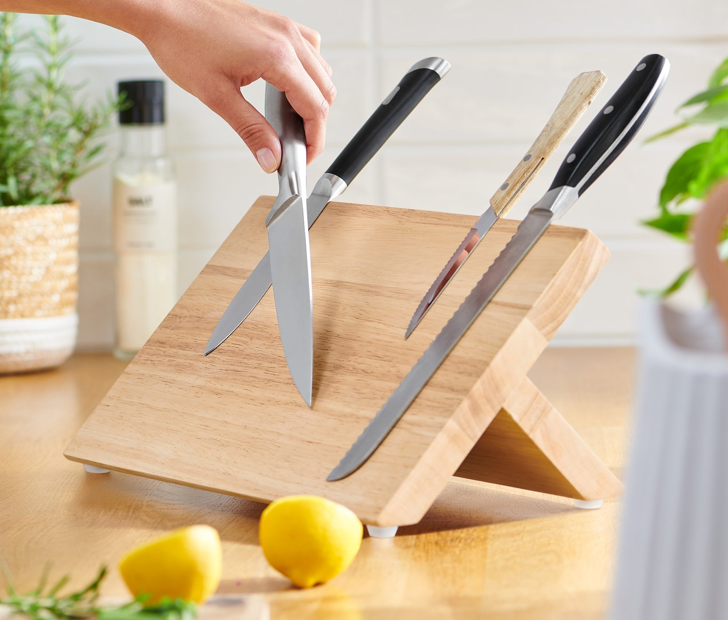 Egy kéz egy kést helyez egy mágneses késtartóra.