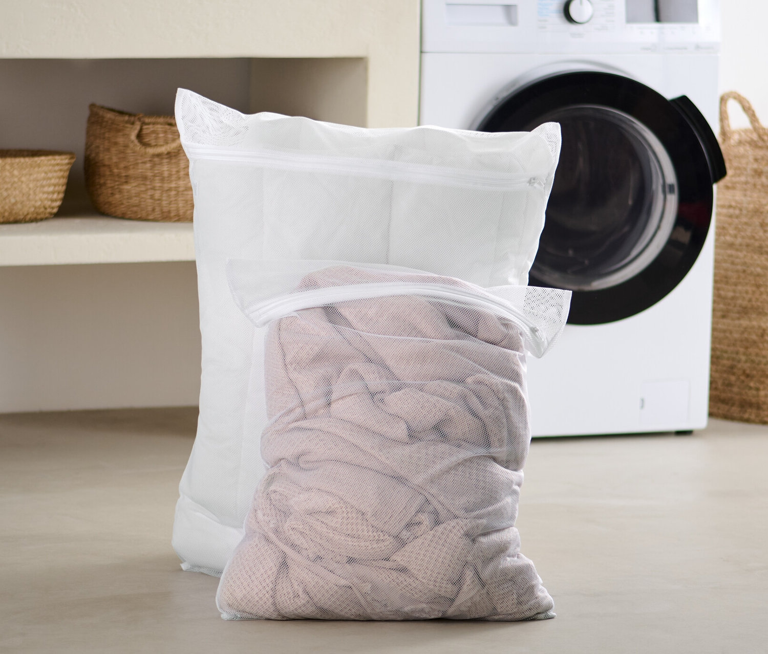 Két extra nagyméretű mosóháló áll a fürdőszobában a mosógép előtt.