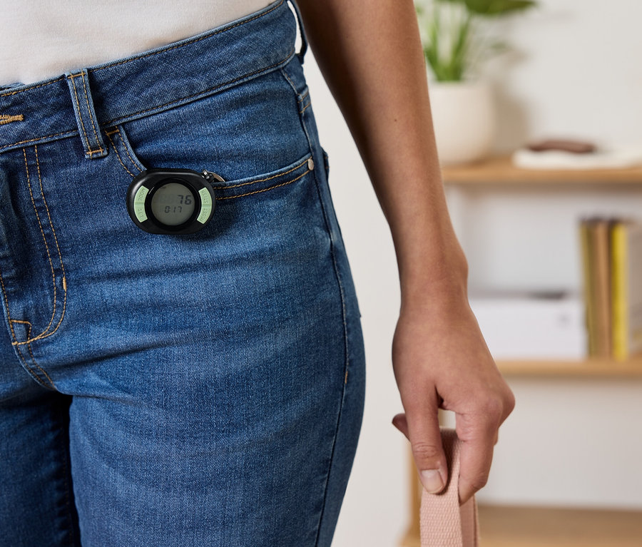 Egy fekete lépésszámláló van rögzítve egy kék farmer első zsebére.