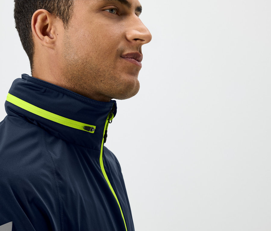 Egy férfi profilja sötétkék kabátban, sárga részletekkel.