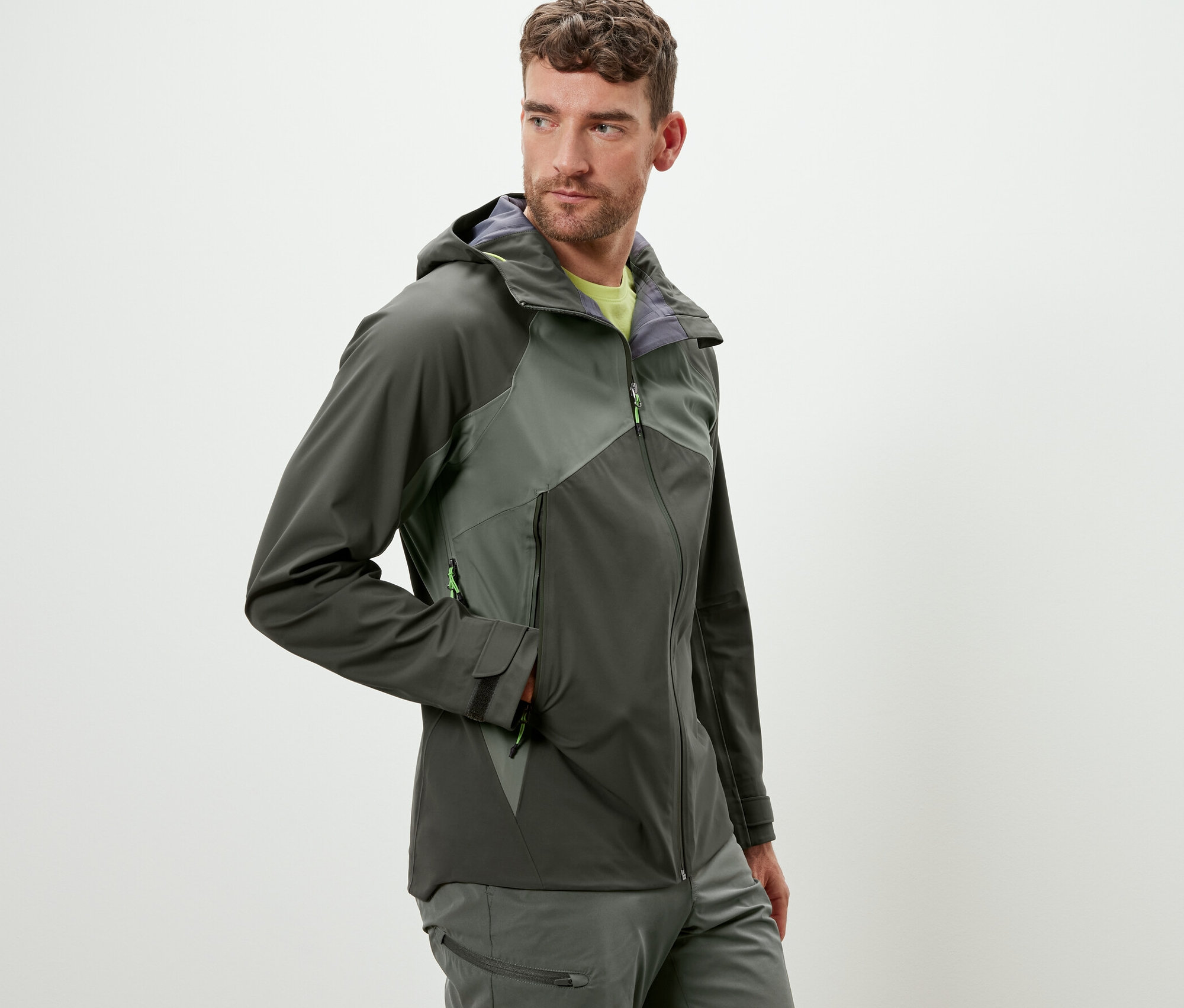 Férfi visel egy khaki színű, 3 rétegű túradzsekit.