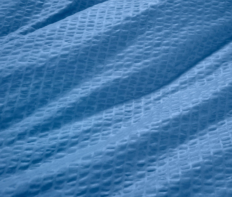 Kék krepp ágynemű részlete.