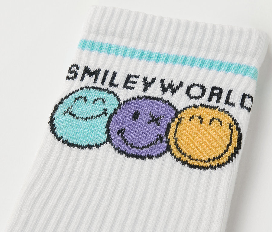 Közelkép egy 5 pár SMILEYWORLD® gyerek sportzokniról, színes mosolygós fejekkel.
