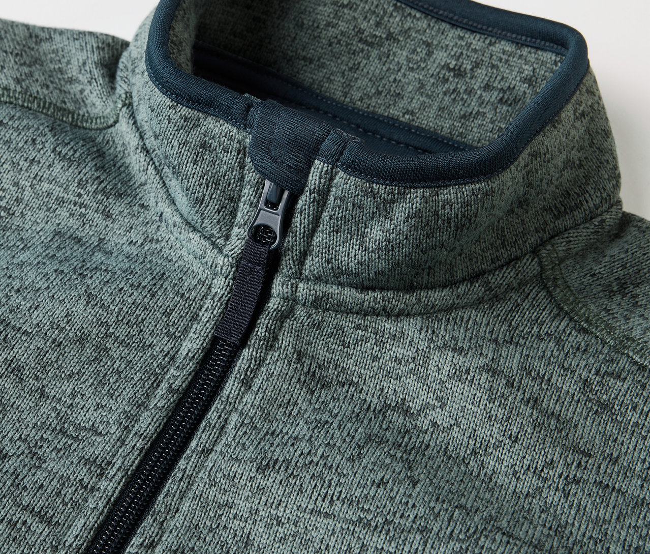 Egy cipzáras gyerek hibrid kötött polárfelső részlete.