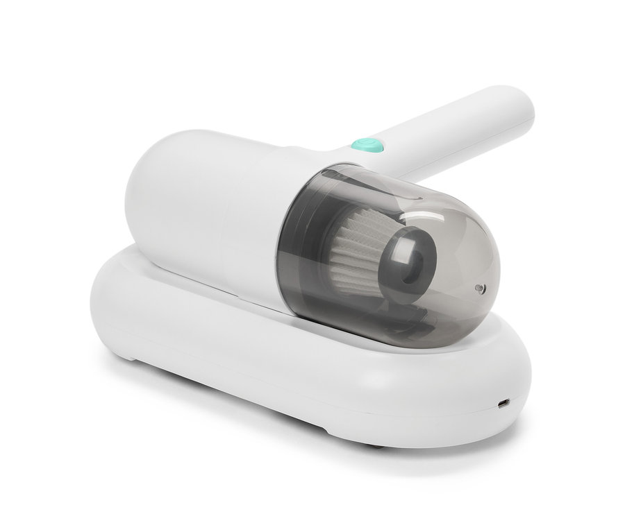 Fehér atkaporszívó egy fehér töltőállomáson.