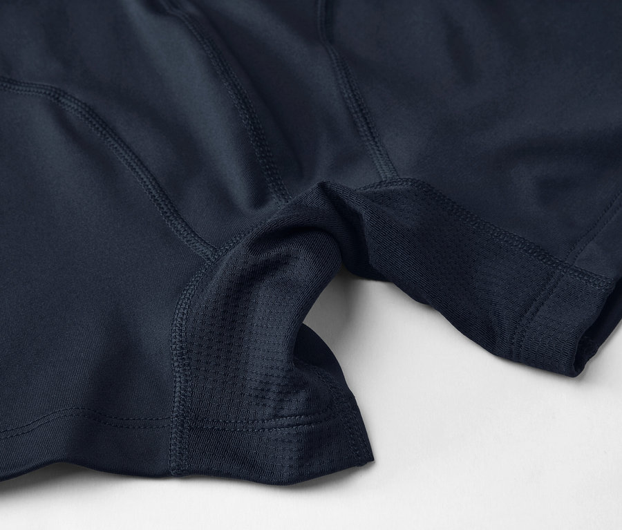 Közeli felvétel egy sötétkék sportalsóról hálós betétekkel és varrással világos háttéren.