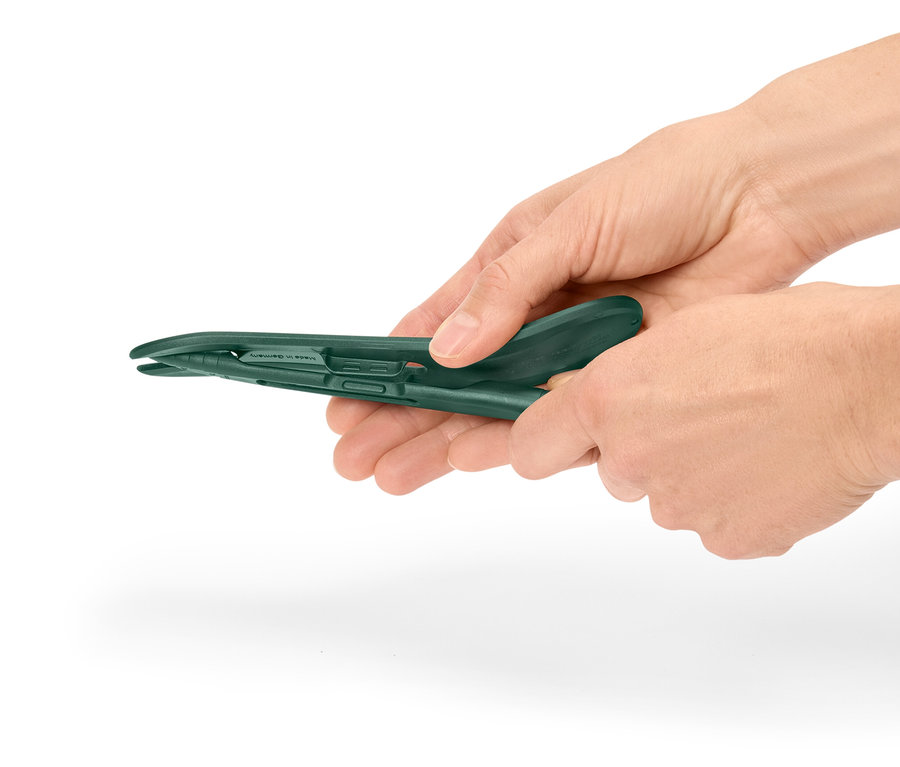 Kezek egy zöld műanyag fogót tartanak.