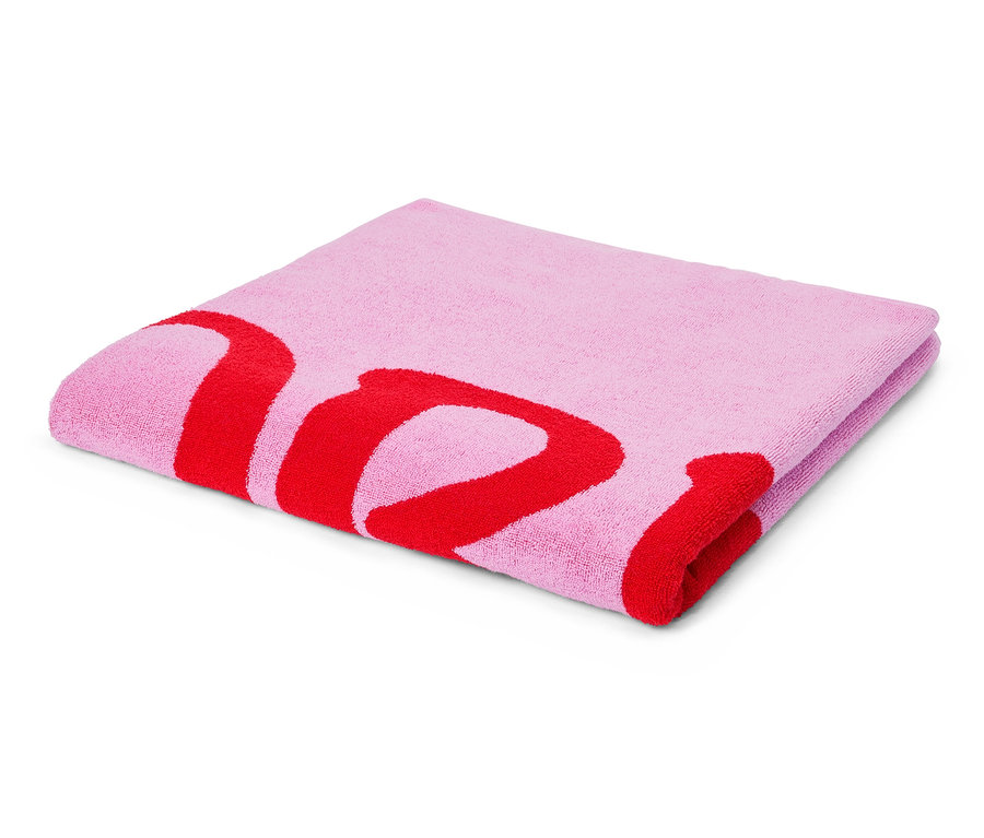 Egy összehajtott, világos rózsaszín törölköző piros betűnyomással fekszik fehér háttéren.