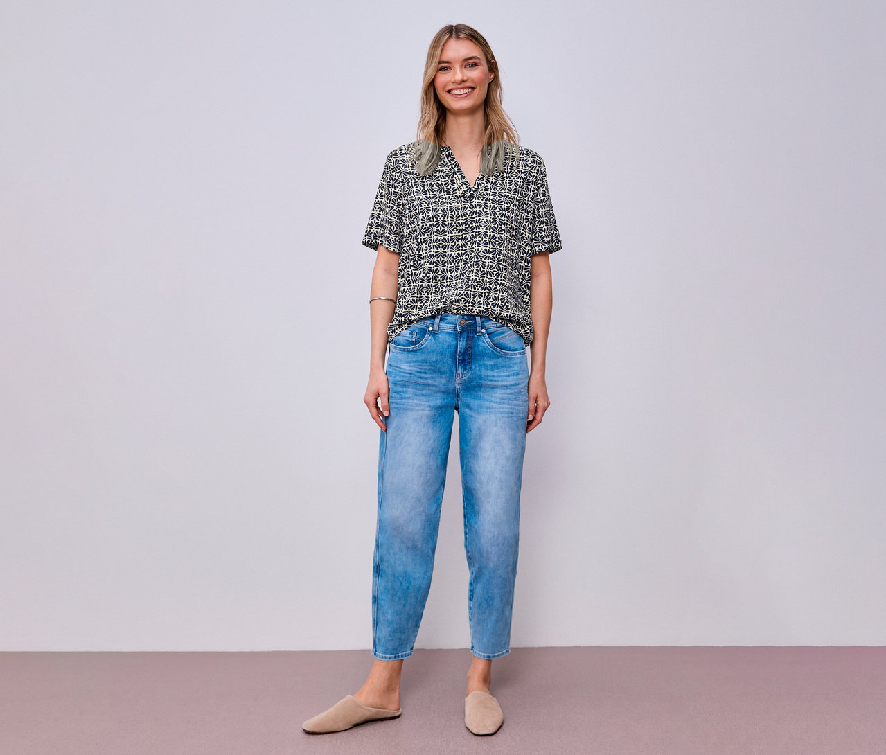 Mosolygó nő farmerban és mintás Street One blúzban.