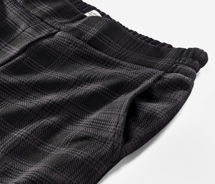 Egy kockás, antracit színű női lezser nadrág részlete.