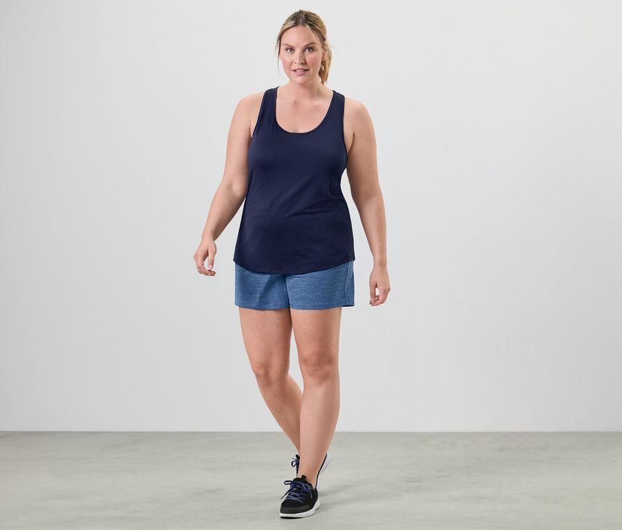 Egy nő sétál és a 2 funkcionális top egyikét viseli, rózsaszín és kék.