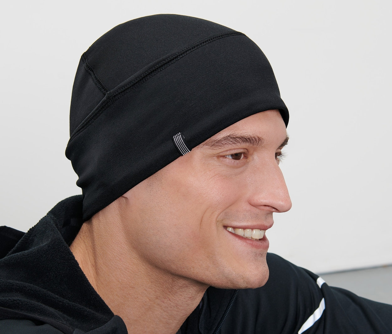 Férfi visel egy fekete termosapkát.