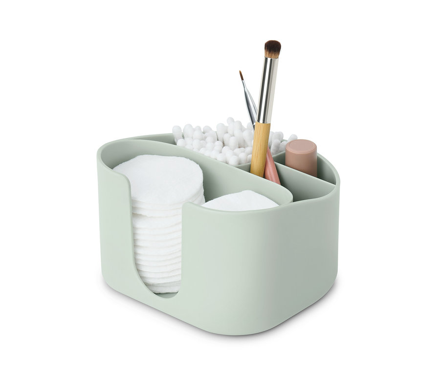 Egy világoszöld piperetartó sminklemosó korongokkal, fültisztító pálcikákkal és sminkecsetekkel.