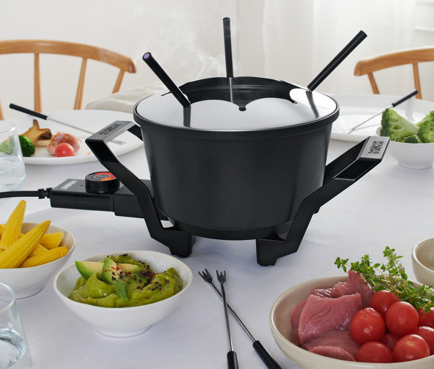Az asztalon egy fondü található nyársakkal és hozzávalókkal.