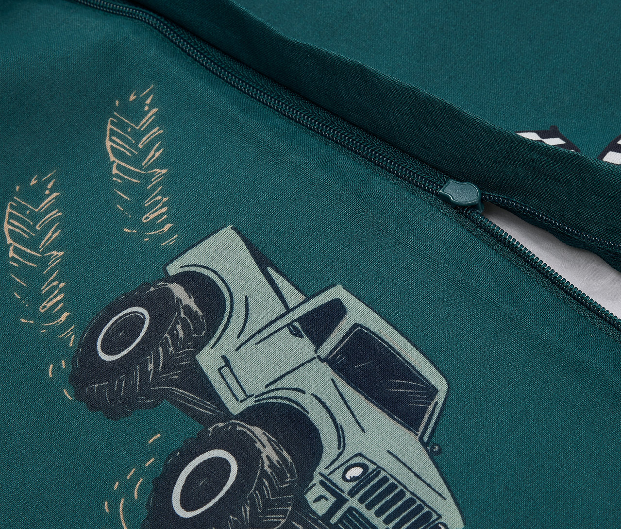 Egy zöld, teherautó mintás Kinder-Renforcé ágynemű részlete.