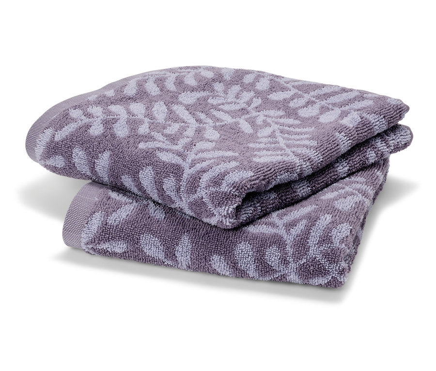 Két lila frottír törölköző van egymásra hajtva. A törölközők finom levélmintával rendelkeznek.