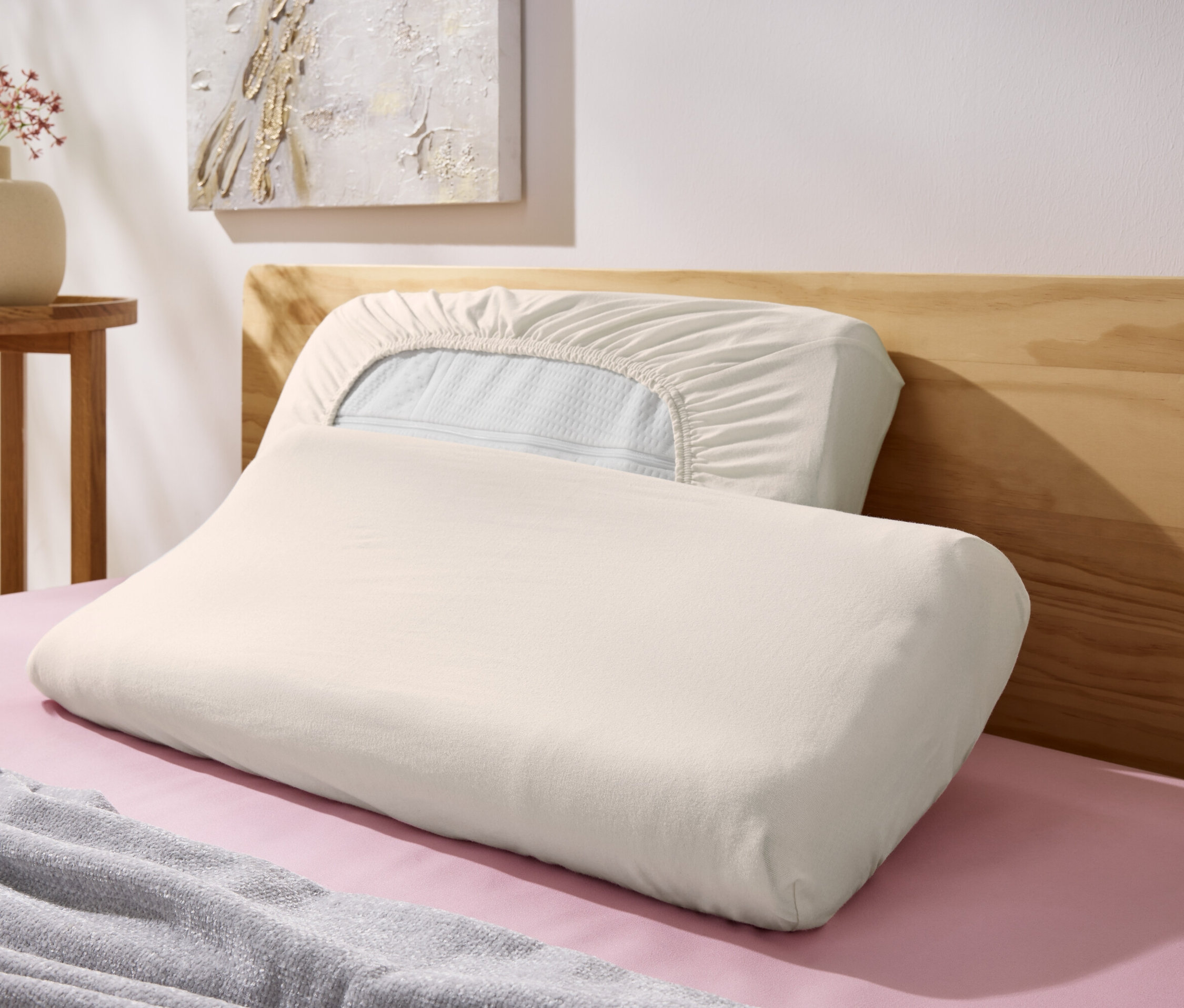 Két törtfehér 2-Jersey-Nackenkissenbezüge fekszik egy ágyon.