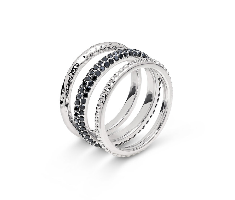 Egy ezüst gyűrű közeli képe négy sorral, egyikük fekete kövekkel.