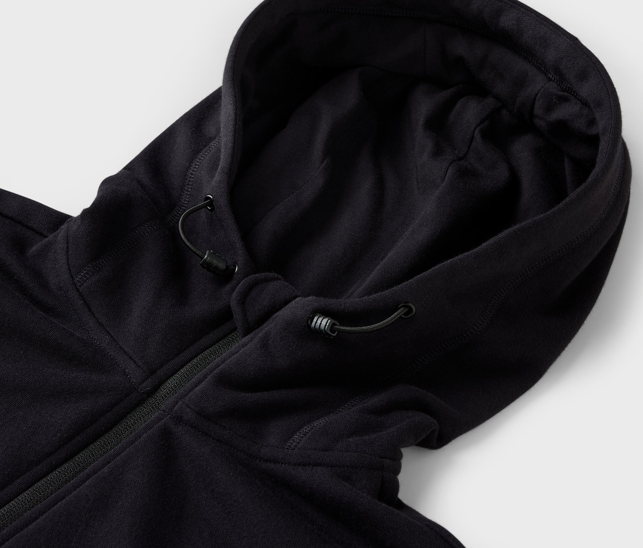 Egy fekete, húzózsinóros kapucnis pulóver részlete.