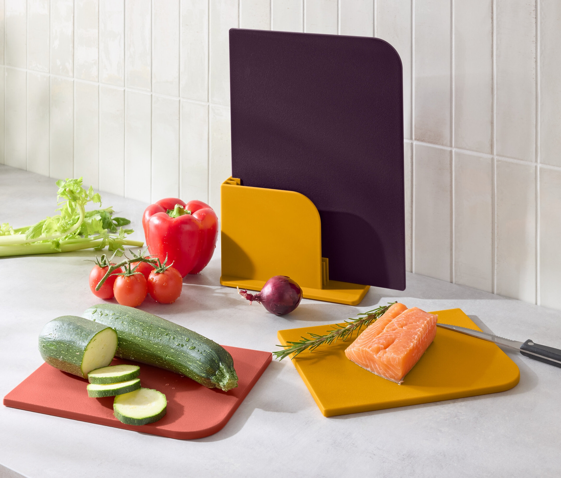 Zöldségek és lazac színes vágódeszkákon.