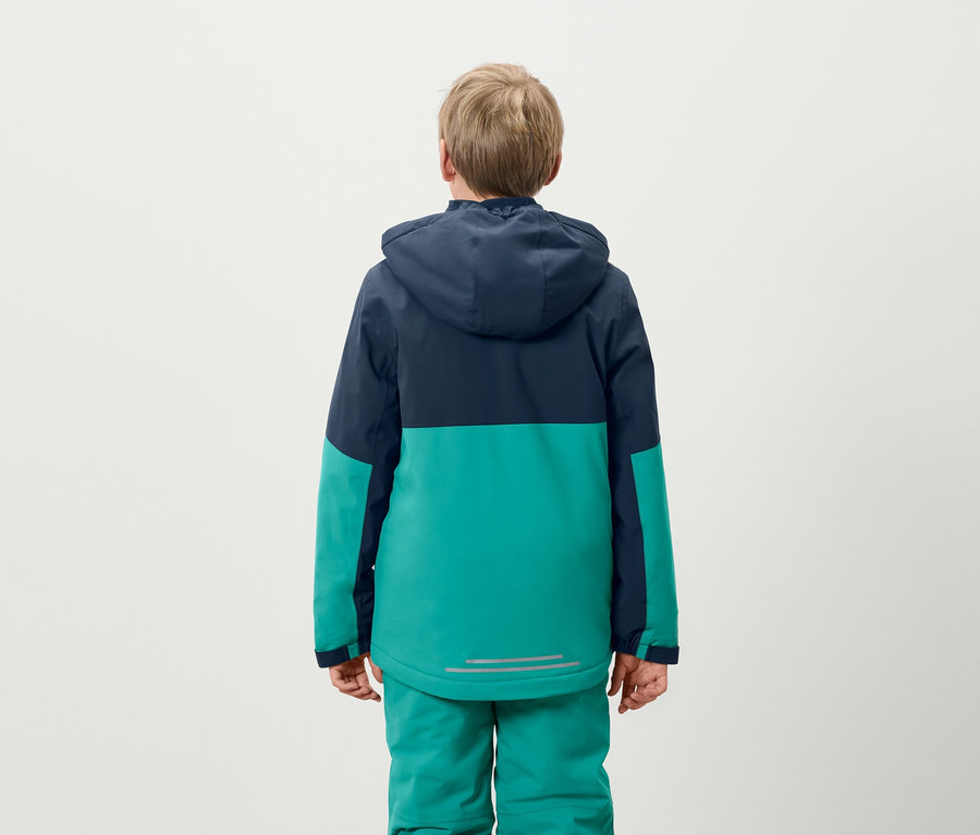 Fiú áll háttal, kék-zöld kabátot és zöld nadrágot visel.