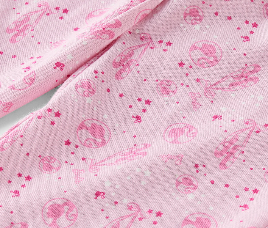 Rózsaszín szövet részlete, balettcipőkkel, csillagokkal és Barbie-sziluettekkel nyomtatva.