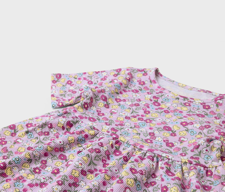 Egy lila, virágmintás ruha részlete.