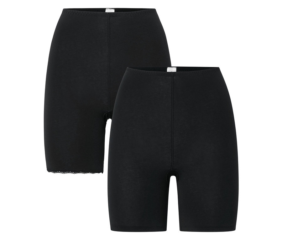Két fekete biciklis rövidnadrág egymáson fekszik fehér háttér előtt.