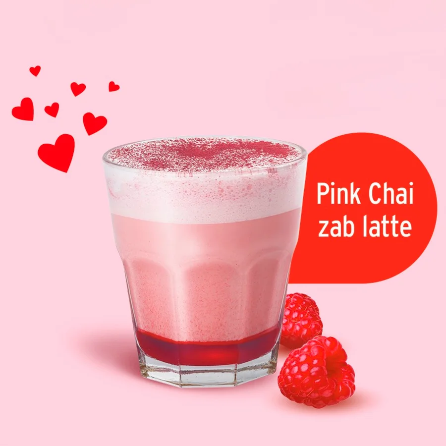 Rózsaszín chai latte málnával és szív alakú díszítéssel.