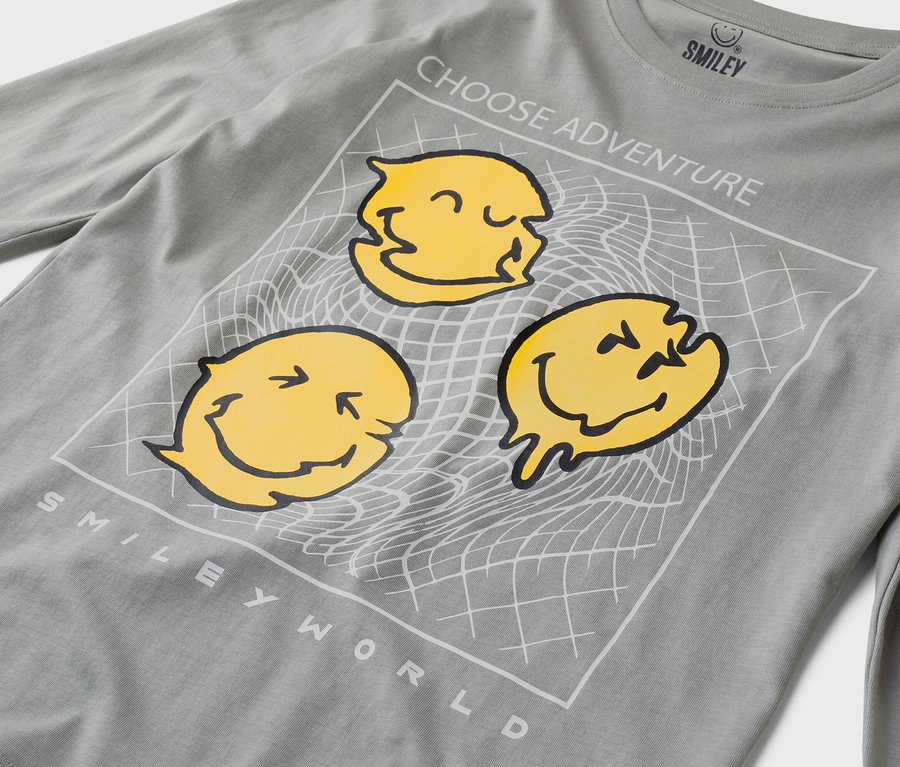 Szürke, hosszú ujjú póló három sárga mosolygós arccal, valamint a „Choose Adventure” és a „Smiley World” felirattal.