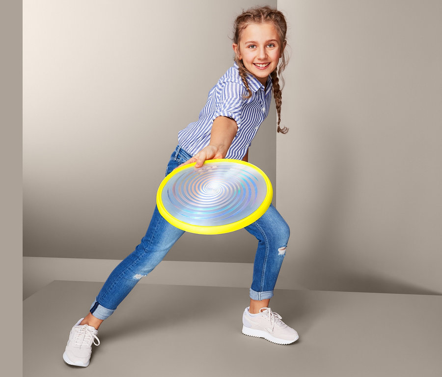 Lány LED-es frizbit dob.