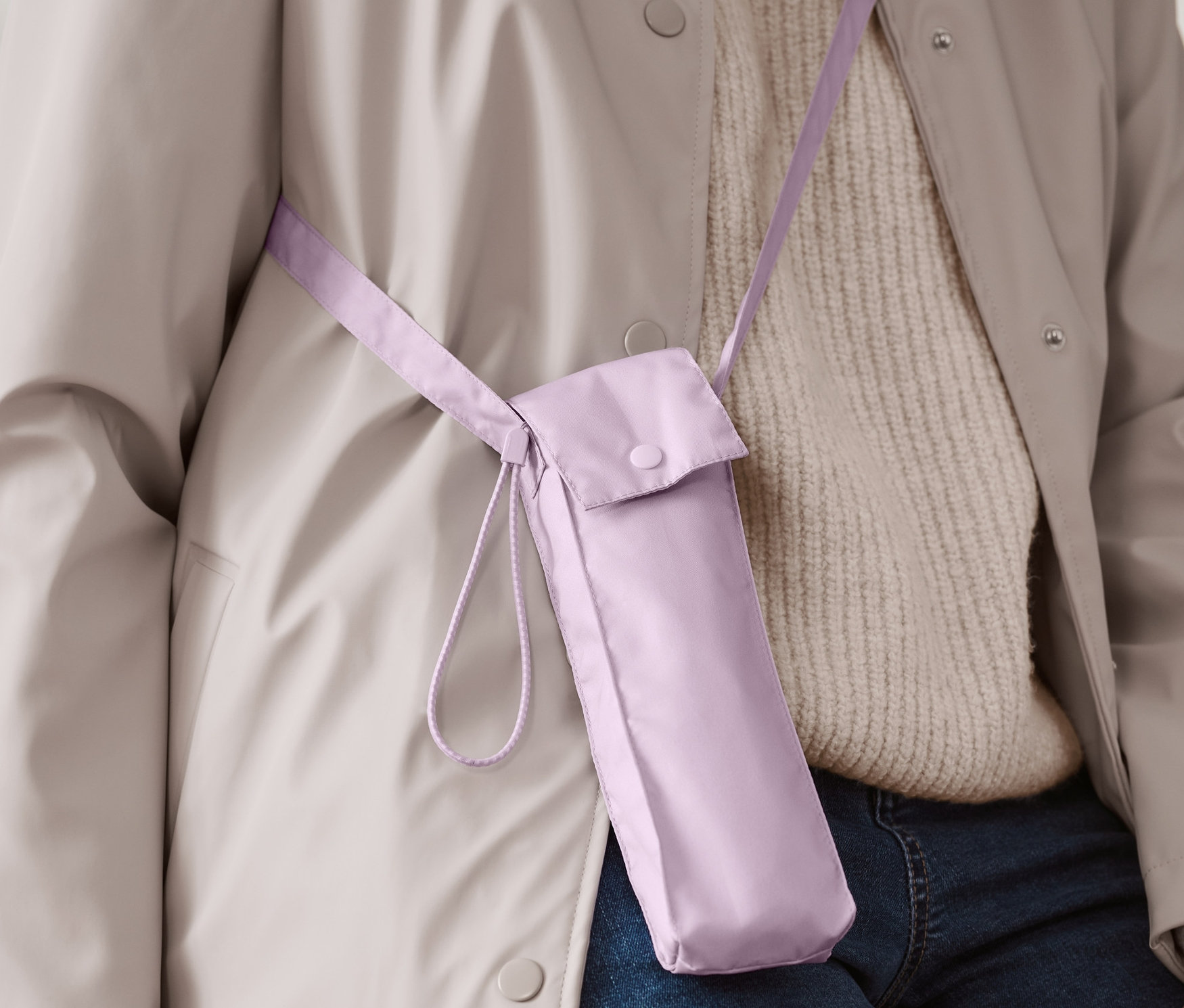 Egy személy világos lila mini táskaesernyőt visel vállpánttal.