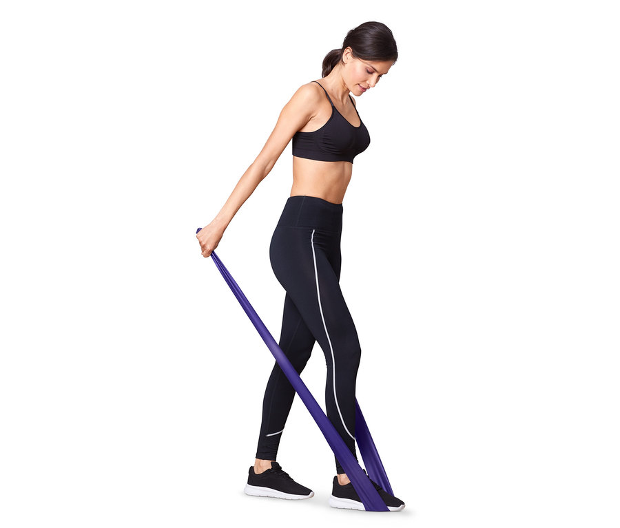 Nő edz egy lila fitneszszalaggal, egy a 2 fitneszszalag és 2 gumiszalag közül.