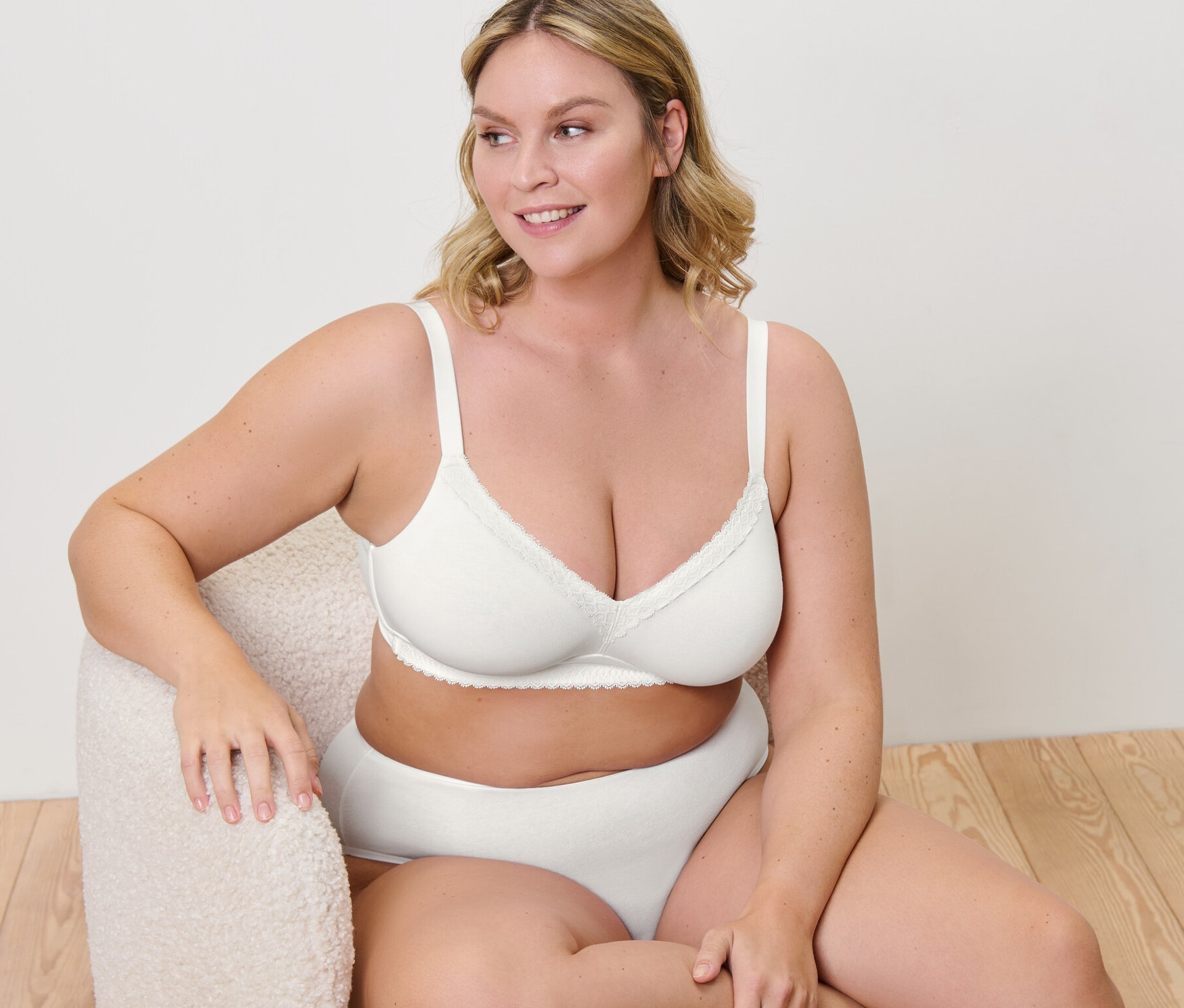 Nő ül egy fotelben, és női puha melltartót visel.