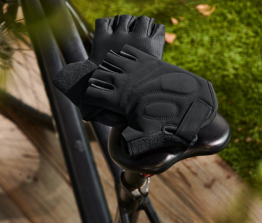 Fekete zselés kerékpáros kesztyűk fekszenek egy kerékpár nyergén.